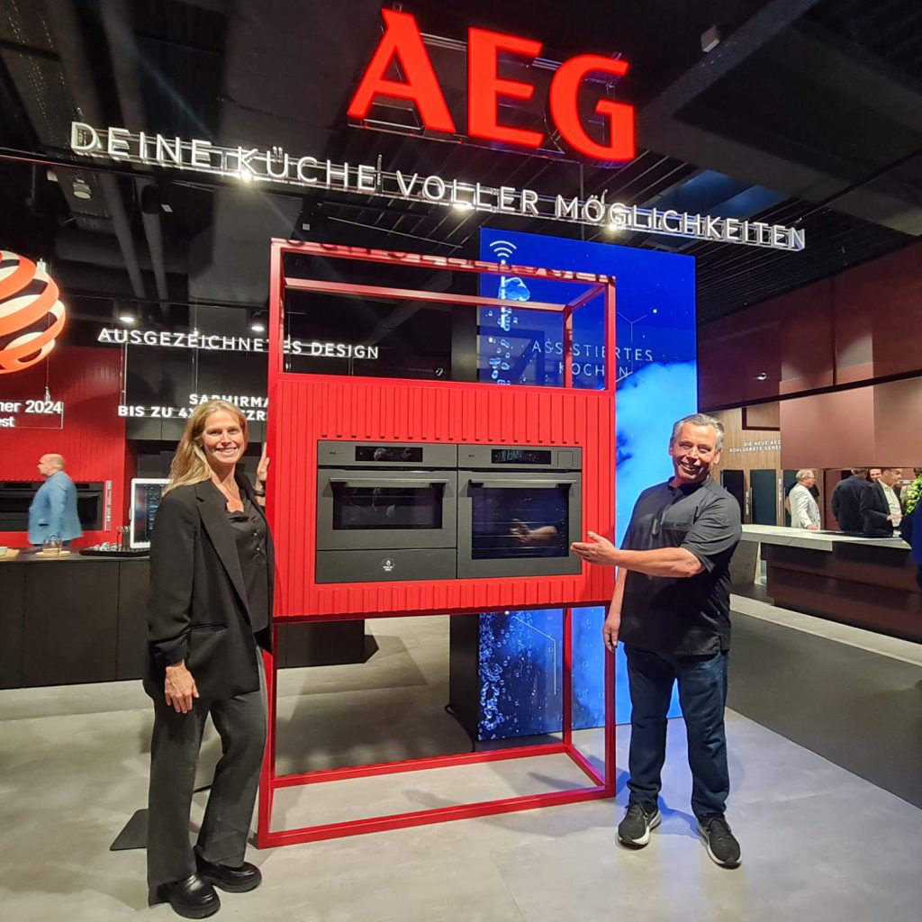 Was für ein fulminanter AEG Aufschlag: neue Küchenlinie, neues „Home of AEG“, neues Look & Feel der Premium Marke. Auf unserem Foto: Marketingleiterin Nina Wünsch und Markenbotschafter Christian Mittermeier.