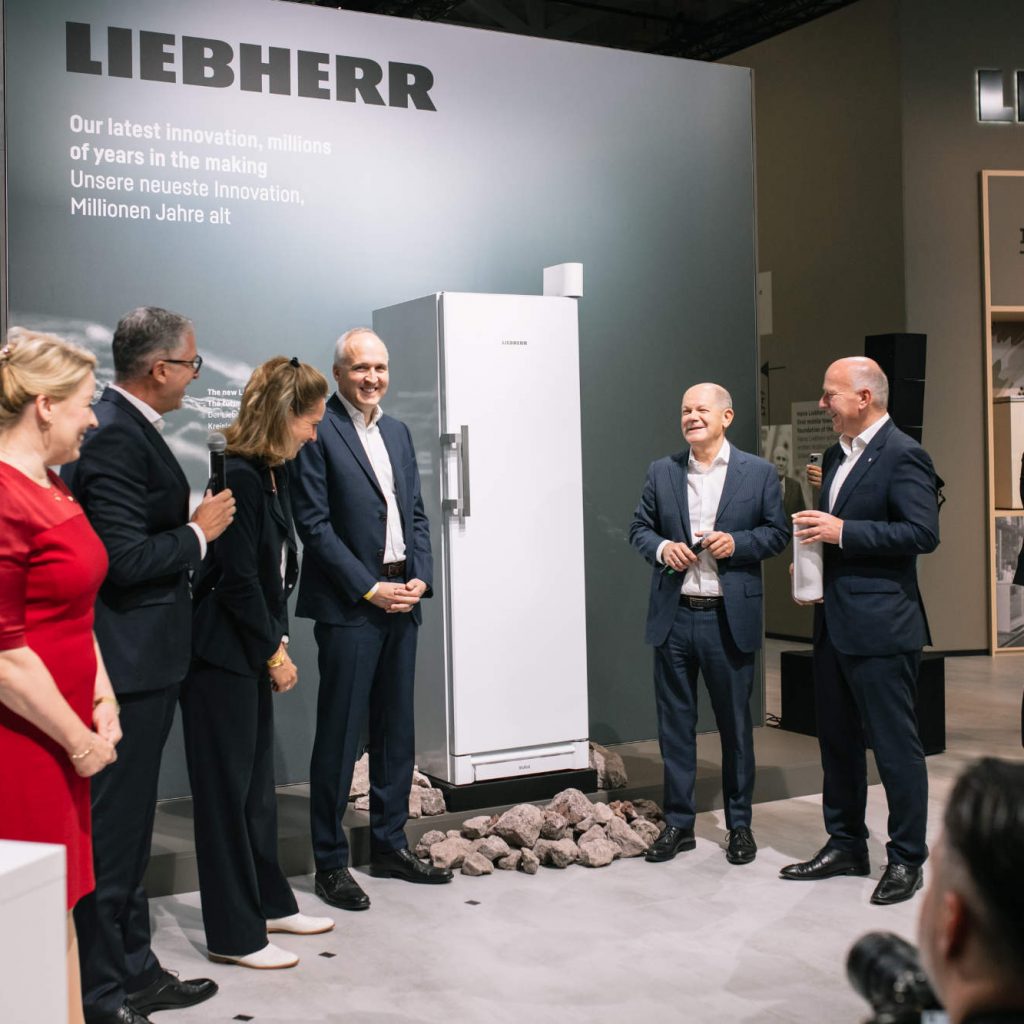 Wer wird denn dem Kanzler da Steine in den Weg legen wollen. Olaf Scholz zu Gast bei Liebherr mit Jan Liebherr (Präsident Verwaltungsrat, Liebherr-International AG), Stéfanie Wohlfarth (Vizepräsidentin Verwaltungsrat, Liebherr-International AG), Steffen Nagel (Geschäftsführung Vertrieb & Marketing), Franziska Giffey und Kai Wegner. Bei den Steinen handelt es sich um Perlit. Als weltweit einziger Hersteller verwendet Liebherr zur Isolierung seiner Geräte ein Vakuum in Verbindung mit fein gemahlenem Lavagestein.